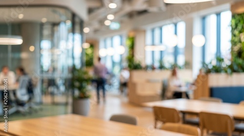 Blurred modern open space office background with green plant walls and soft lighting. Sustainable interior workspace, corporate biophilic design, commercial eco concept.