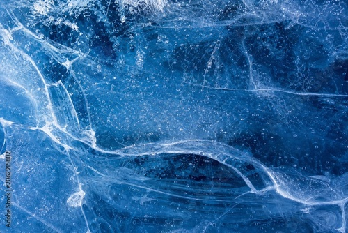 Inside a glacier, blue textures and white veins from frozen bubbles.