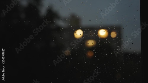 Large raindrops on the window during the rain against the background in the night