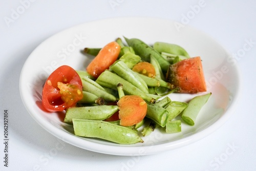 Fotografie Small portion of organic vegetable food waste trashes on white plate isolated on horizontal white background
