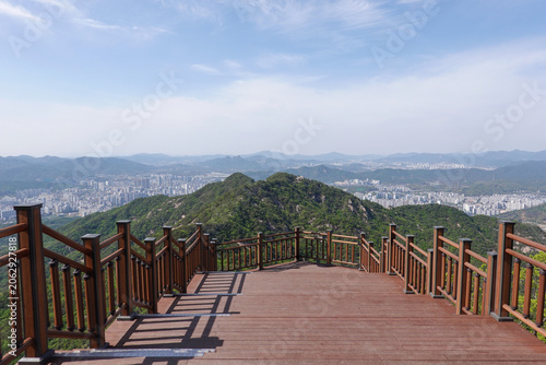 Foto Wooden observation deck empty viewpoint overlooking green mountains and city und