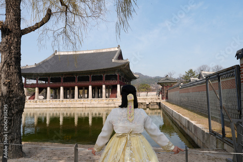 Bild auf Leinwand Back view of woman in hanbok facing Gyeonghoeru Pavilion at Gyeongbokgung Palace