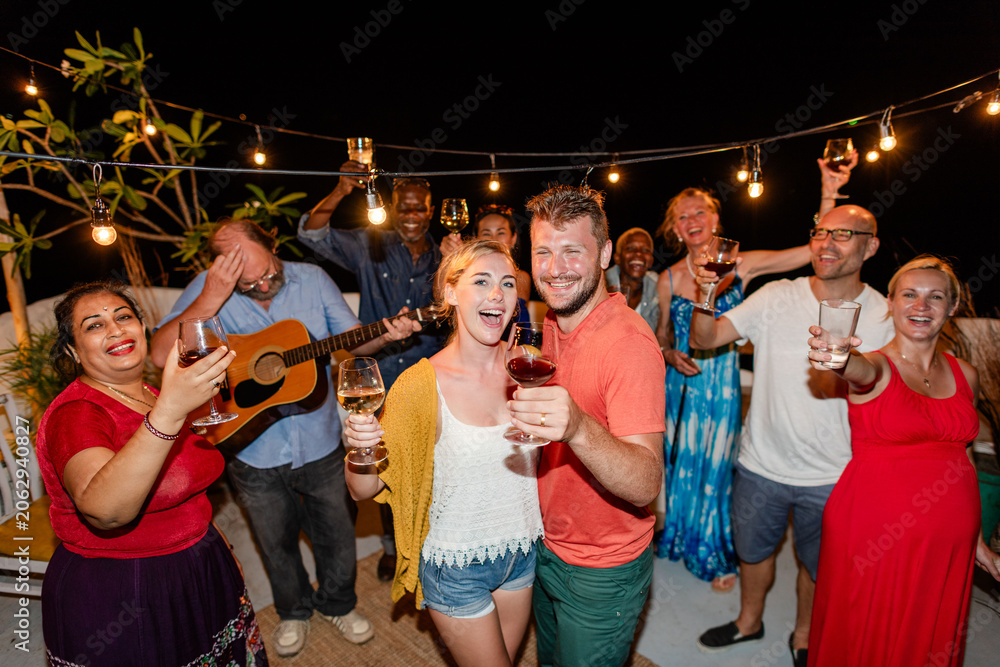 Fototapeta premium Diverse group of men and women enjoying a lively outdoor party