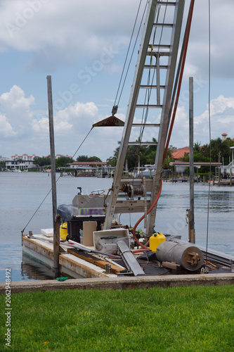 Fotografie Work Boat Docked on Quiet Canal Near Mangroves Under Cloudy Sky With Reflections Crisp Park in St