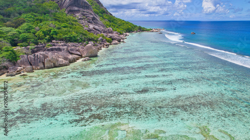 Εκτύπωση καμβά High-angle drone shot of the world-famous Anse Source d'Argent beach in Seychelles, showcasing spectacular weathered granite rocks, white sand, lush palms, and clear turquoise water