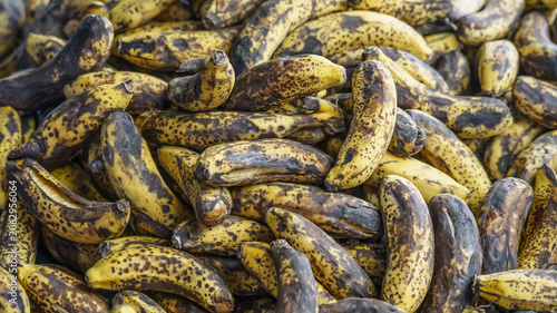 Foto Pile of ripe, overripe bananas with dark spots and yellow skin, arranged closely