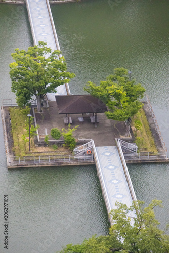 Small island pavilion connected by footbridges in reservoir