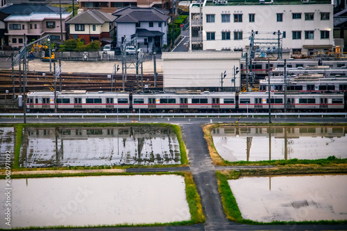 Commuter train beside flooded rice paddies