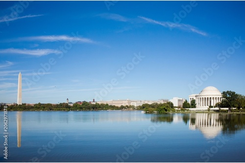 Photos Wide-angle view of the Washington Monument and Jefferson Memorial reflected in the Tidal Basin under a clear blue sky