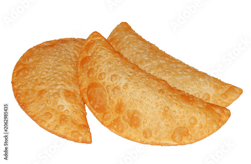 THREE GOLDEN CRISPY FRIED EMPANADAS OR TRADITIONAL BRAZILIAN PASTEL ISOLATED ON A CLEAN WHITE BACKGROUND. DELICIOUS SAVORY PASTRY SNACK