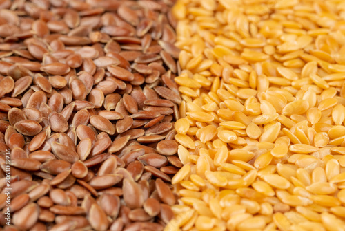 Pile of raw flaxseeds divided into golden and brown halves for background. Close-up