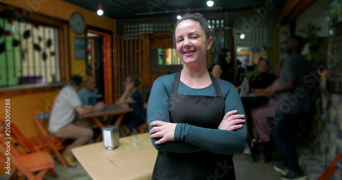 Φωτογραφία Young woman small business worker standing alone inside café with arms crossed s