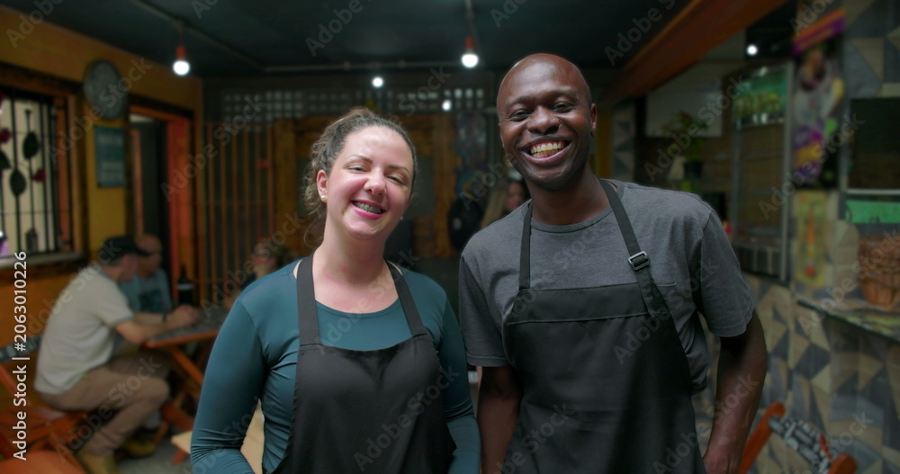 Obraz premium Smiling small business café staff standing together inside neighborhood restaurant conveying teamwork warmth hospitality trust shared effort pride community connection