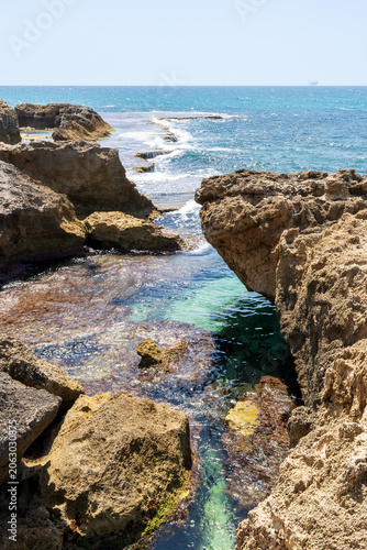 Picturesque Mediterranean coastline with turquoise waters, distinctive kurkar rock formations, and rich marine biodiversity, renowned for its natural beauty and tranquil atmosphere.