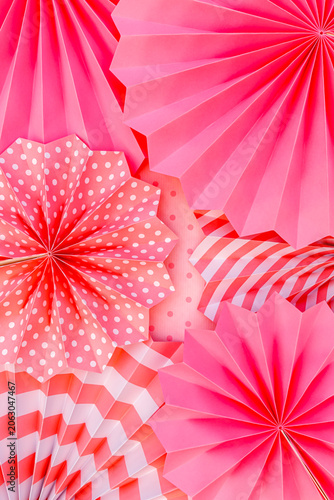 Colorful paper decorations are arranged on a surface for a party or celebration event