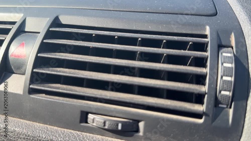 Close-up of central air vents and hazard button on a car dashboard, vehicle ventilation controls, automotive interior, driving equipment.