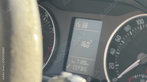 Close-up of a car instrument cluster showing speedometer, digital clock, fuel level and odometer mileage, driver information, dashboard controls, vehicle monitoring.