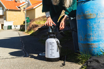 Senior Woman Preparing Cleaning Equipment in Village