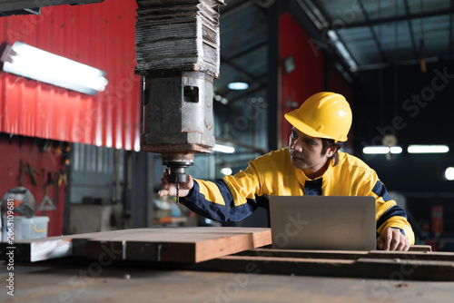 Foto Industrial worker at work, inspecting or maintenance vertical drilling machine i