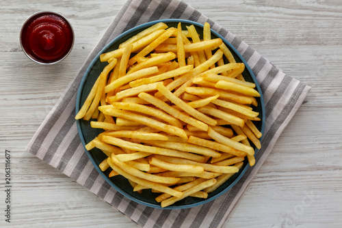 Homemade French Fries and Ketchup on a White Wooden Background, top view.