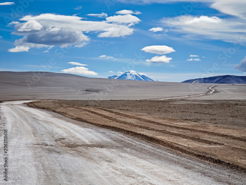 Vista escénica de ángulo alto de una pista sinuosa junto a una laguna salada en la cordillera de los Andes, Balcón del Pissis.