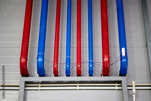 Vivid blue and red water supply pipes illustrating infrastructure and functionality, ideal for projects related to plumbing, construction, and urban development.