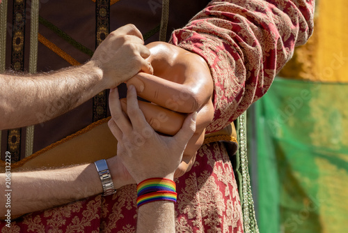 Rainbow Pride Wristband Holding Giant Figure Hand in Traditional Costume, Diversity, Inclusion, Equality and Cultural Heritage Concept
