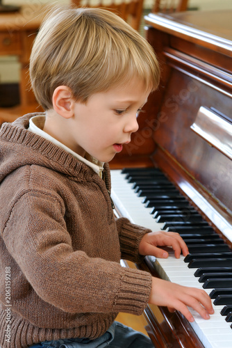 A young boy plays the piano.