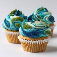 Three Delicious Homemade Earth Day Cupcakes Decorated with Swirled Blue and Cream Buttercream Frosting and Topped with Green Moss Sprinkles to Resemble the Planet Globe Symbolizing Environmental