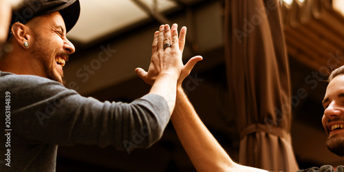 Foto Two friends sharing a joyful high-five outdoors