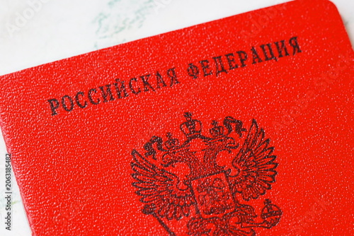 Fotografija A red Russian passport sitting on a table, great for travel or cultural themed p