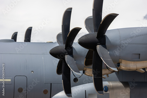 Close view large turboprop propeller military transport aircraft dramatic cloudy sky. Powerful aerospace propulsion system engineering precision aerodynamic efficiency advanced aviation technology