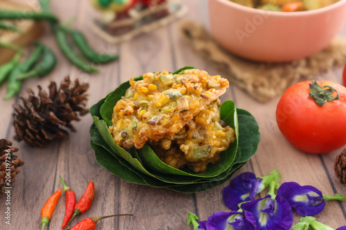 Foto Bakwan jagung, also called dadar jagung, is an Indonesian fritter made from mashed corn kernels and spices, deep-fried until golden, firm, and crispy
