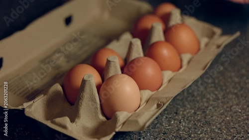 choosing which eggs to eat from a cardboard carton.