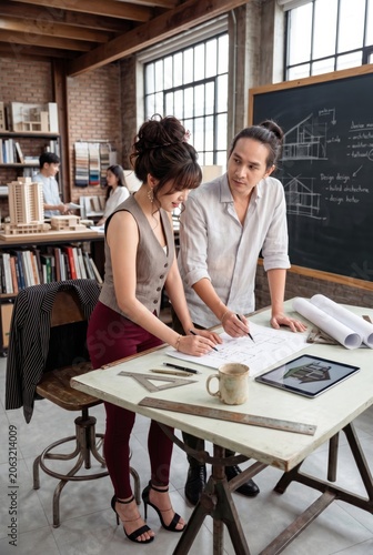 Business partners working on documents and digital tablet in creative loft office