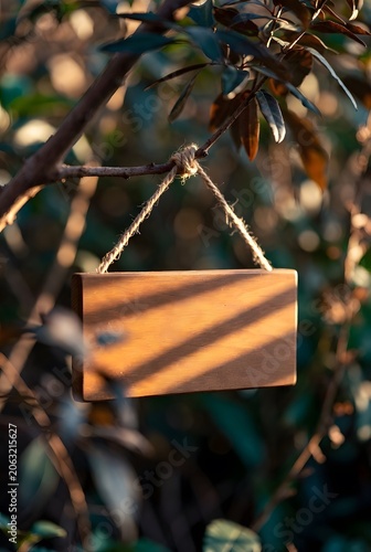 Rustic Wooden Sign Hanging from Rope in Nature for Information, Advertising and Marketing Messages. High-quality professional photograph featuring a rustic wooden sign board suspended by a rope 