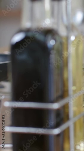 Vertical video: Shifting camera showing rack with dark bottle and pale right bottle at counter