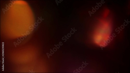 Defocused multicolored lens flare studio light leak overlay with organic amber orange bokeh orbs, rainbow prism edge and dark cinematic glow