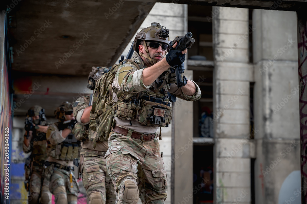 Fototapeta premium Special armed military squad team in full gear patrolling an abandoned building during hostage crisis