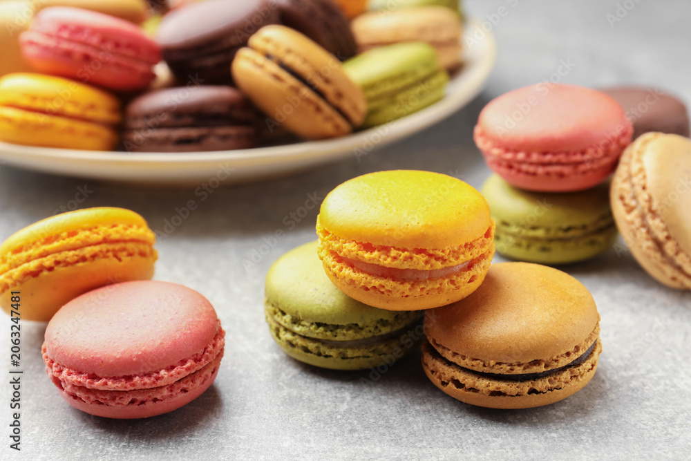 Fototapeta premium Yummy colorful macarons on light grey table, closeup