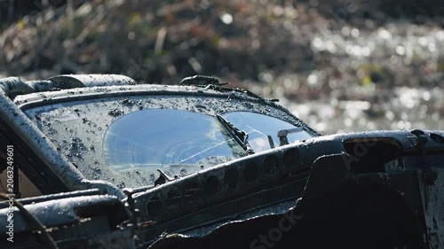 Close up of rugged 4x4 vehicle splattered with mud during intense off road competition. Wipers clear windshield for visibility. Extreme motorsport challenge