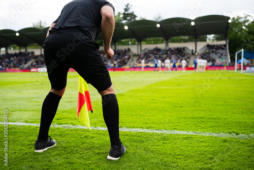 Quadro em tela Assistant referee standing on the touchline during a football match, watching pl