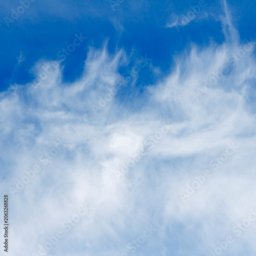 A clear blue sky with wispy white clouds scattered across horizon.