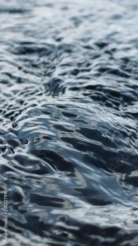 Slow motion dark water ripples textured fluid nature background