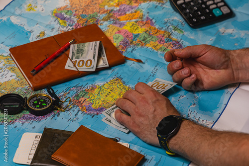 Planning a travel budget with cash and a map for a future trip