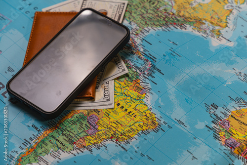 Travel accessories for planning a trip with a world map and smartphone