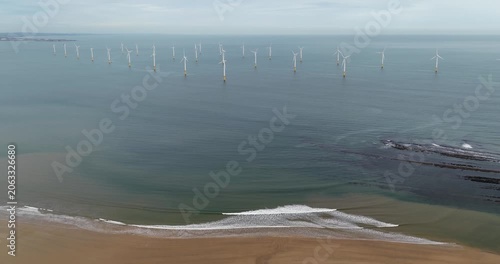 Aerial view of offshore wind turbines near Redcar and Middlesbrough on the North East coast of England showing sandy beach gentle waves coastal waters sandy beach and renewable energy infrastructure