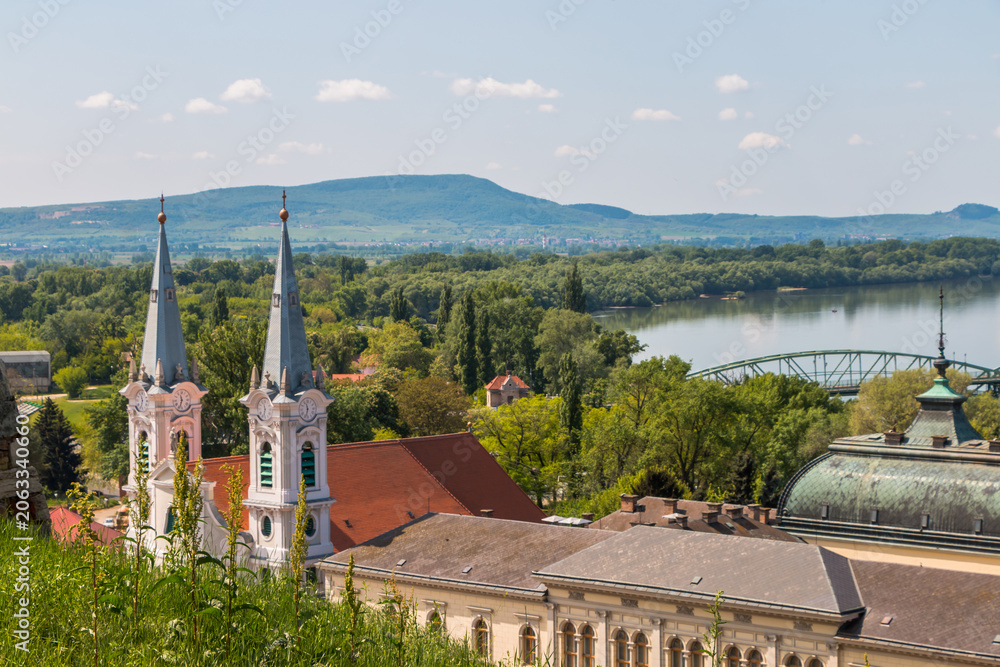 Fototapeta premium A panorama of Esztergom, Hungary. View of the towers of St. Ignatius Church in the Watertown district, the dome of the Esztergom Basilica, and the Danube River.