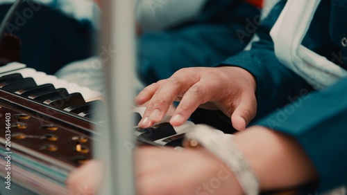 Indian child hands plays Sikh prayer music with harmonium keyboard during Vaisakhi