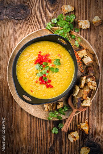 Traditional Indian style dal lentil soup dal tadka with roasted flatbread served as top view in a design pot